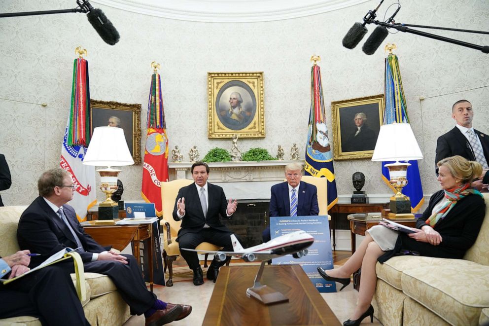 PHOTO: President Donald Trump listens as Florida Governor Ron DeSantis speaks during a meeting in the Oval Office of the White House in Washington, April 28, 2020.