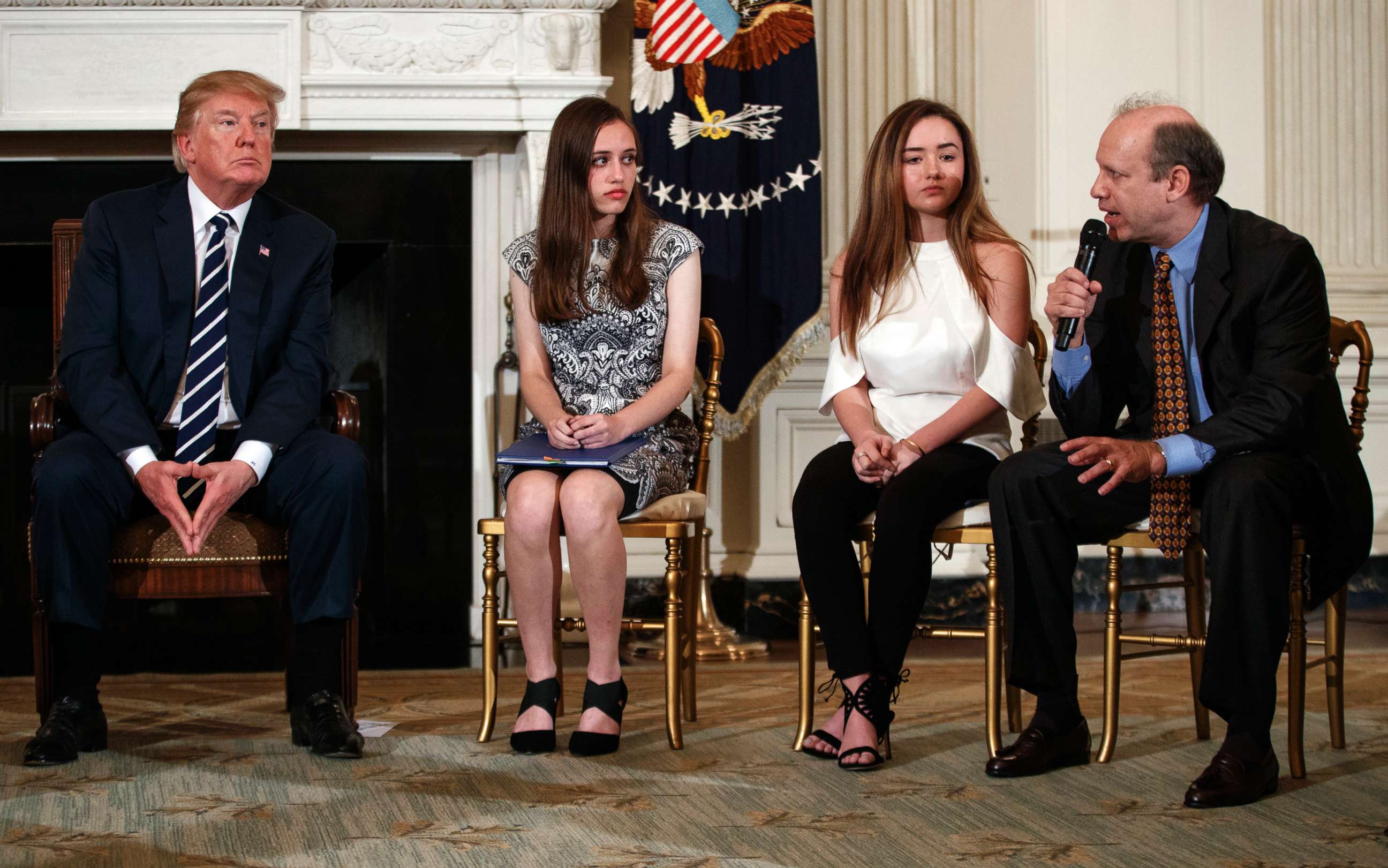 PHOTO: From left, President Donald Trump, Marjory Stoneman Douglas High School students Carson Abt and Ariana Klein, listen as Carson's father Frederick Abt, speaks in the State Dining Room of the White House in Washington, D.C., Feb. 21, 2018.