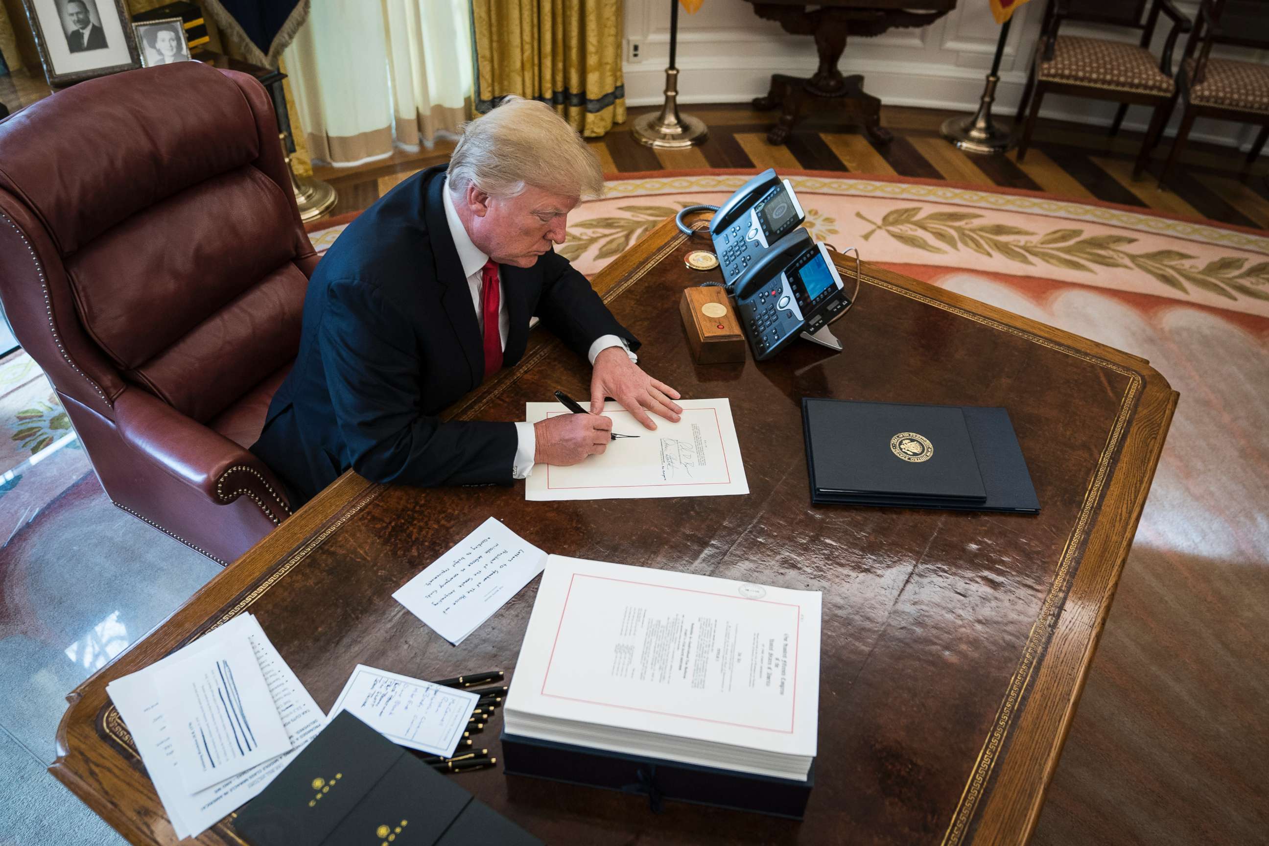 PHOTO: President Donald Trump signs the Tax Cut and Reform Bill, a $1.5 trillion tax overhaul package, into law in the Oval Office at the White House in Washington, D.C., Dec. 22, 2017. 