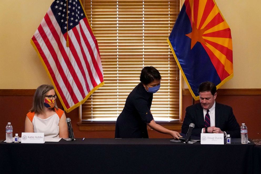 PHOTO: Arizona Secretary of State Katie Hobbs Arizona looks on as Arizona Elections Director Bo Dul gives Arizona Gov. Doug Ducey, elections documents to sign to certify the election results on Nov. 30, 2020, in Phoenix.