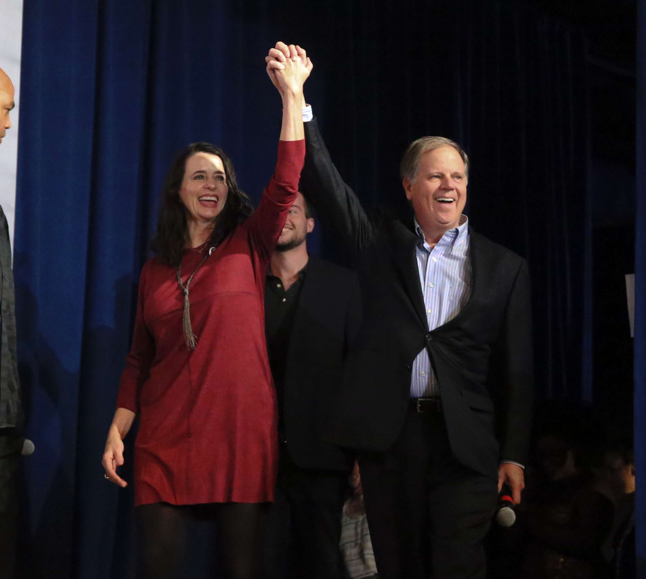 PHOTO: Democratic candidate for U.S. Senate Doug Jones and his wife Louise wave to supporters as they walk on stage during a rally Monday, Dec. 11, 2017, in Birmingham, Ala.