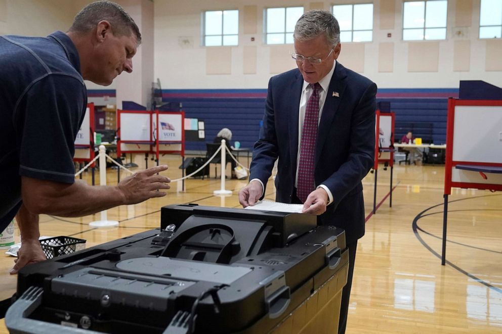 PHOTO: Chris Doughty, right, casts his ballot, as election worker Todd Duffy, left, looks on, Sept. 6, 2022, in Wrentham, Mass., in the state's primary election.