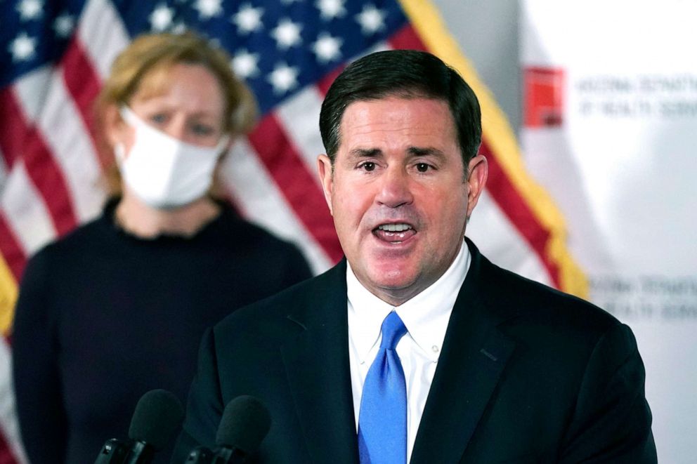 PHOTO: Arizona Republican Gov. Doug Ducey, right, talks about the latest Arizona COVID-19 information during a news conference as Arizona Department of Health Services Director Dr. Cara Christ listens, Dec. 2, 2020, in Phoenix. 