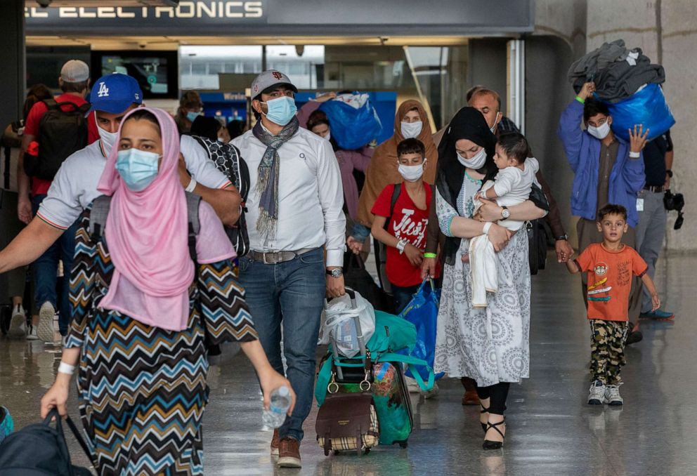 PHOTO: Families evacuated from Kabul, Afghanistan, walk through the terminal to board a bus after they arrived at Washington Dulles International Airport, in Chantilly, Va., on Sep. 1, 2021.