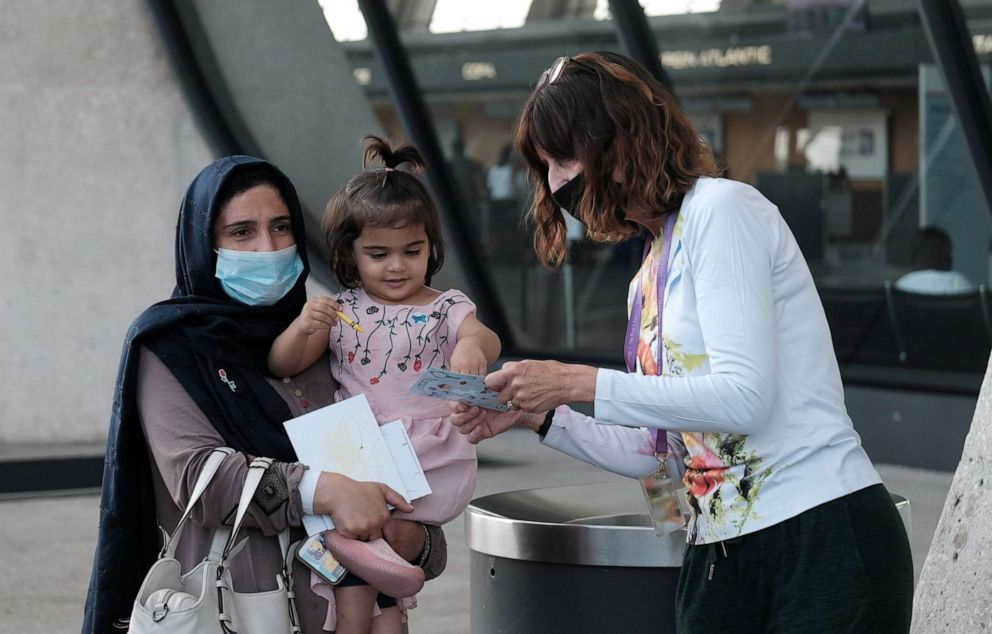 PHOTO: Afghan refugees speak with a State Department employee upon arrival at Dulles International Airport in Chantilly, Va., Aug. 28, 2021.