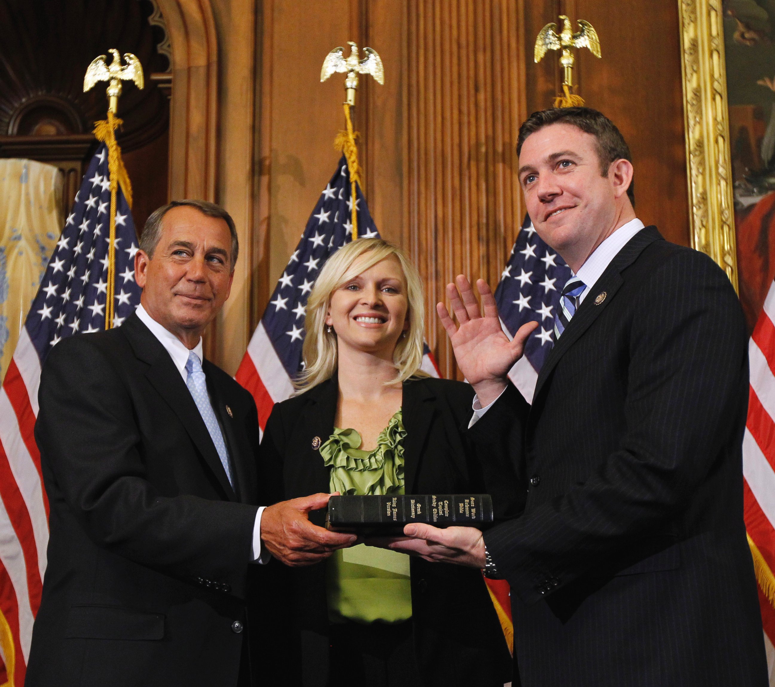 In this Jan. 5, 2011, file photo, House Speaker John Boehner of Ohio, left, administers the House oath to Rep. Duncan Hunter, R-Calif., as his wife, Margaret, looks on during a mock swearing-in ceremony on Capitol Hill in Washington. 