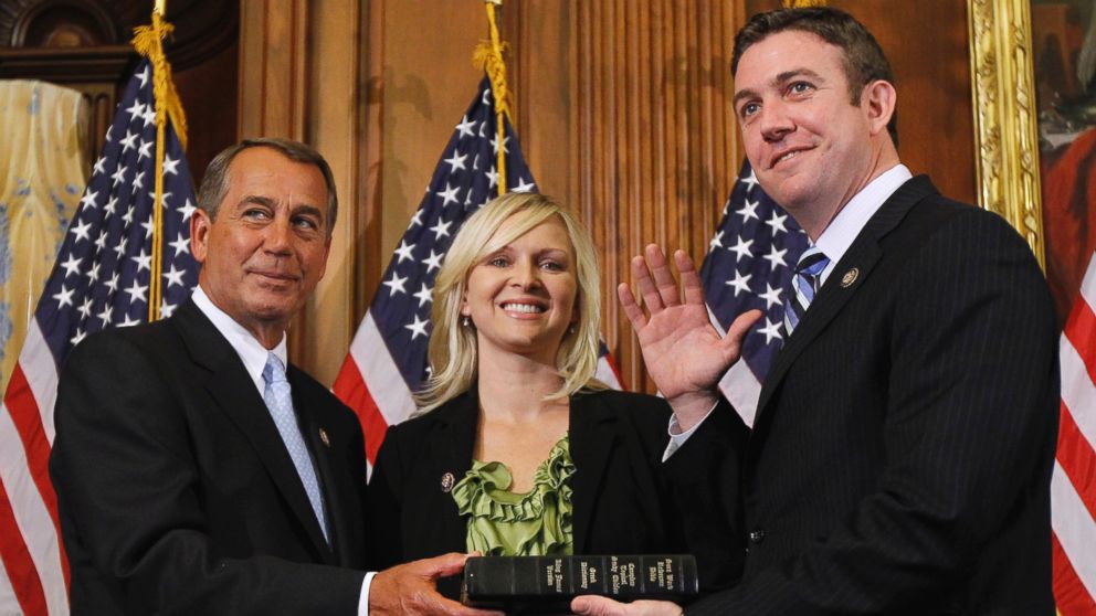 In this Jan. 5, 2011, file photo, House Speaker John Boehner of Ohio, left, administers the House oath to Rep. Duncan Hunter, R-Calif., as his wife, Margaret, looks on during a mock swearing-in ceremony on Capitol Hill in Washington. 