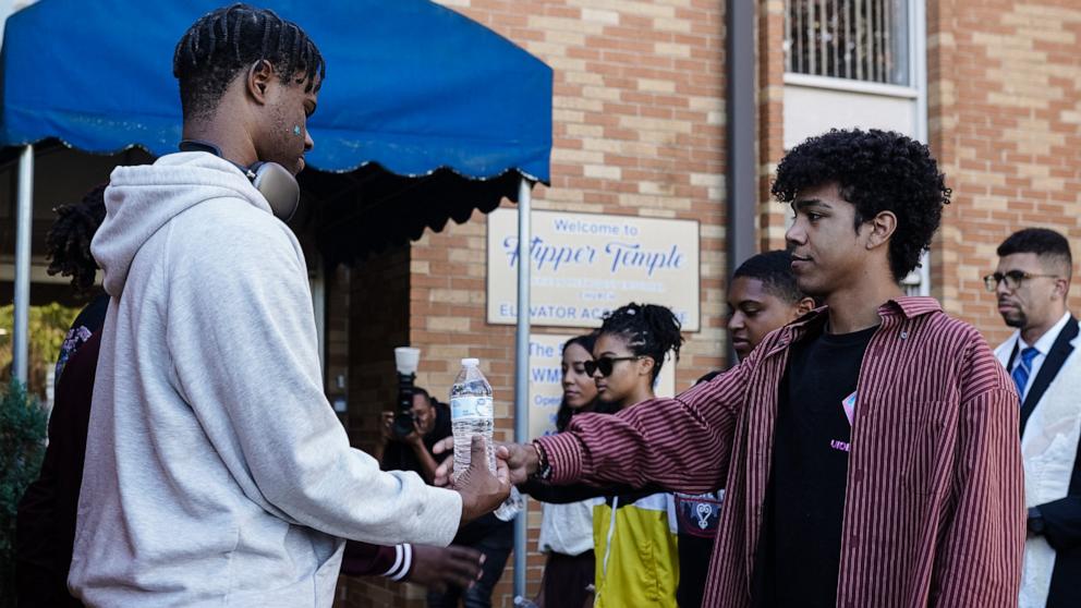 PHOTO: Activists symbolically give water to voters outside an early voting polling location during a protest against Georgia's SB202 law, which prohibits giving food or water to anyone waiting in line to vote, Oct. 19, 2024, in Atlanta.