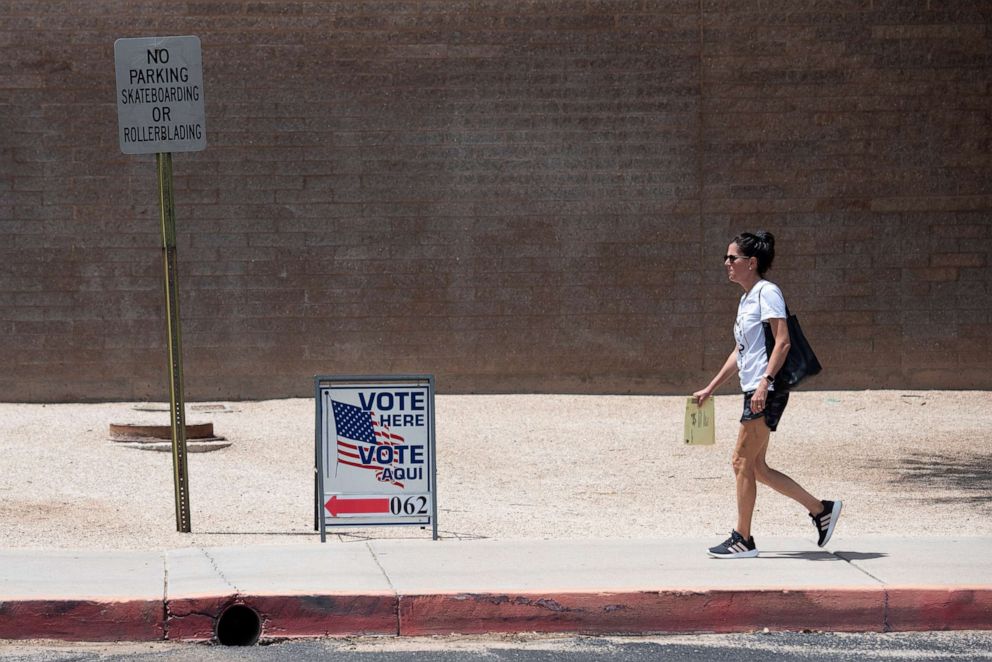 PHOTO: A person carries their early ballot to the polling station at the Morris K. Udall Regional Center during the Arizona primary in Tucson, Arizona August 2, 2022. 