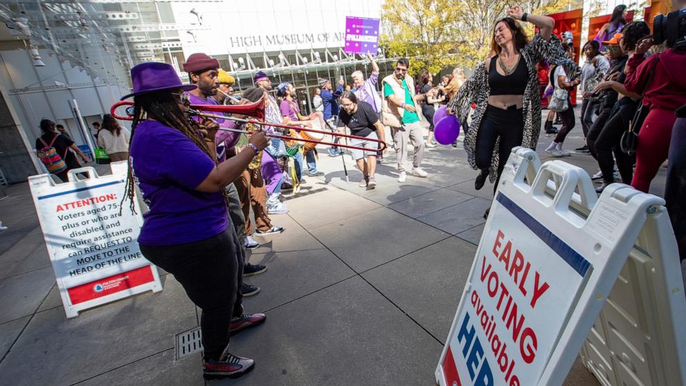 PHOTO: Party to the Polls Purple Tour performers bring joy to a polling location during the early vote period as attendees cast their ballots on Oct. 19, 2024, in Atlanta. 