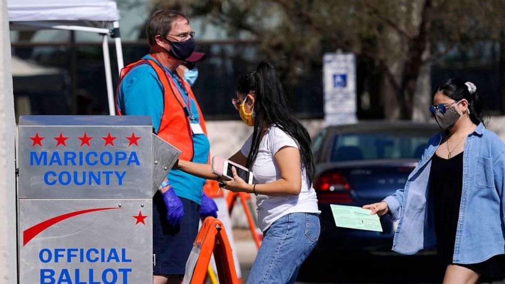 PHOTO: In this Oct. 20, 2020, file photo, voters drop off ballots as volunteers look on at the Maricopa County Recorder's Office in Phoenix.