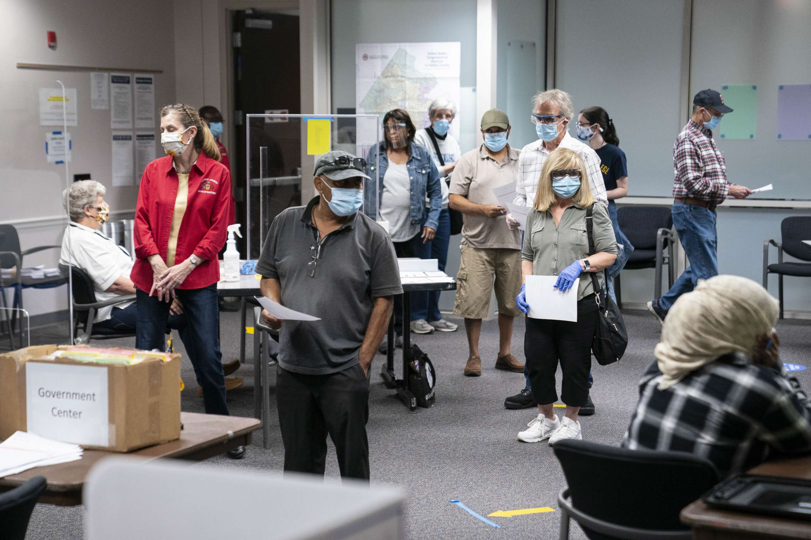 PHOTO: Voters wearing protective masks stand in line to cast ballots at an early voting polling location for the 2020 Presidential elections in Fairfax, Va., Sept. 18, 2020.