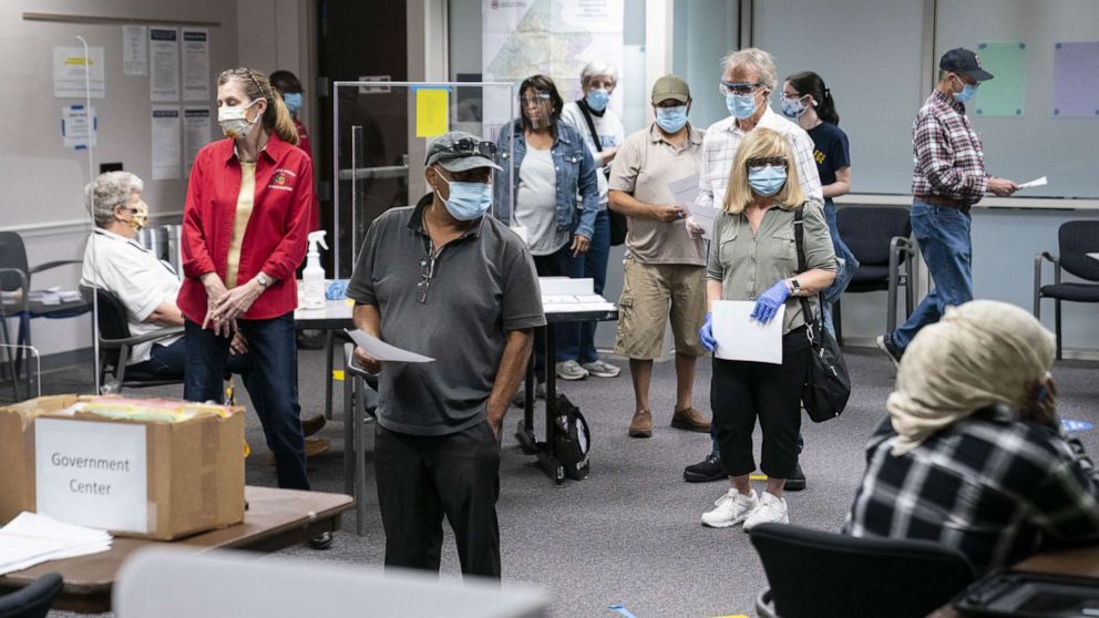PHOTO: Voters wearing protective masks stand in line to cast ballots at an early voting polling location for the 2020 Presidential elections in Fairfax, Va., Sept. 18, 2020.
