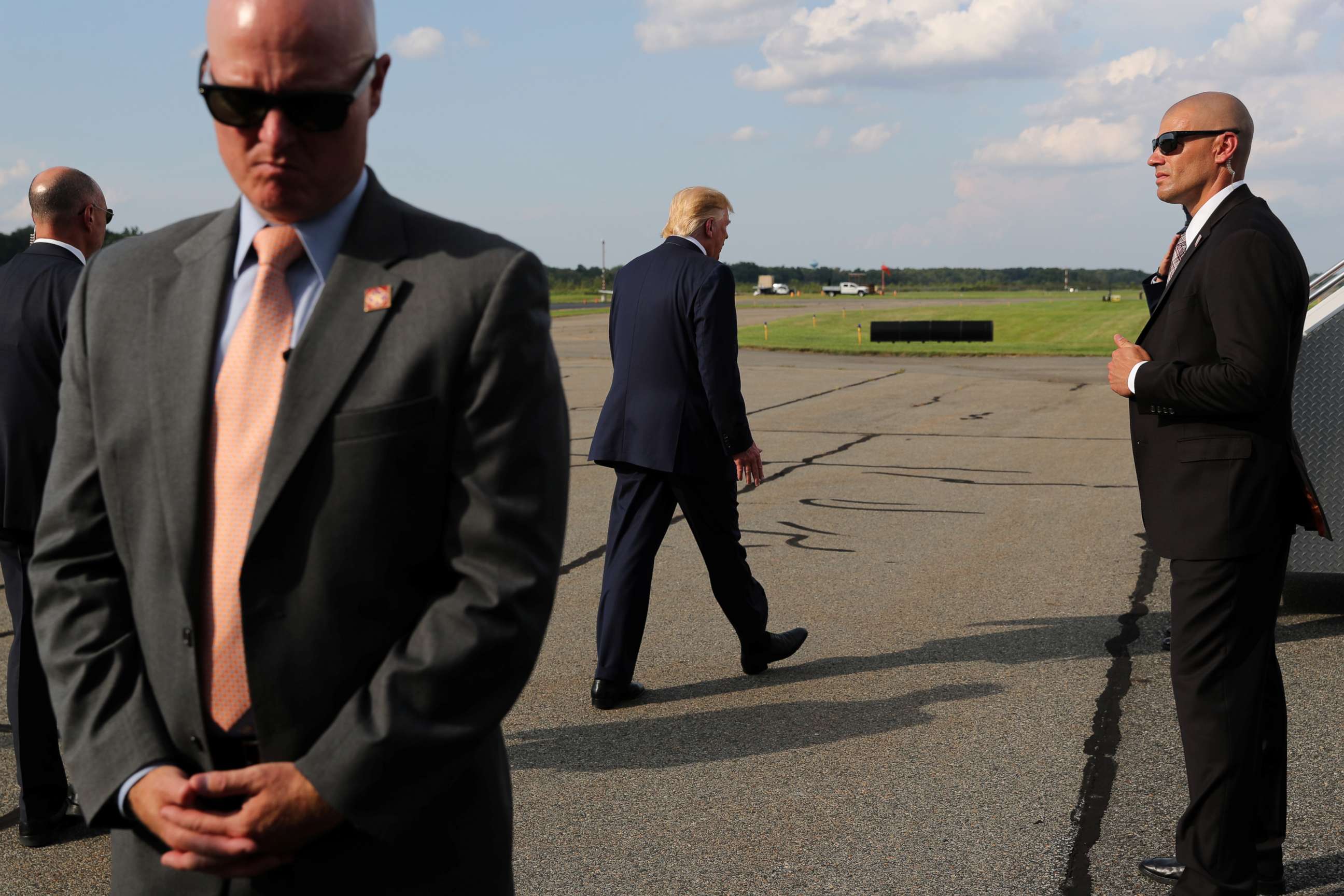 PHOTO: U.S. Secret Service agents guard President Donald Trump as he boards Air Force One to return to Washington from Morristown Municipal Airport in Morristown, New Jersey, Aug. 18, 2019.