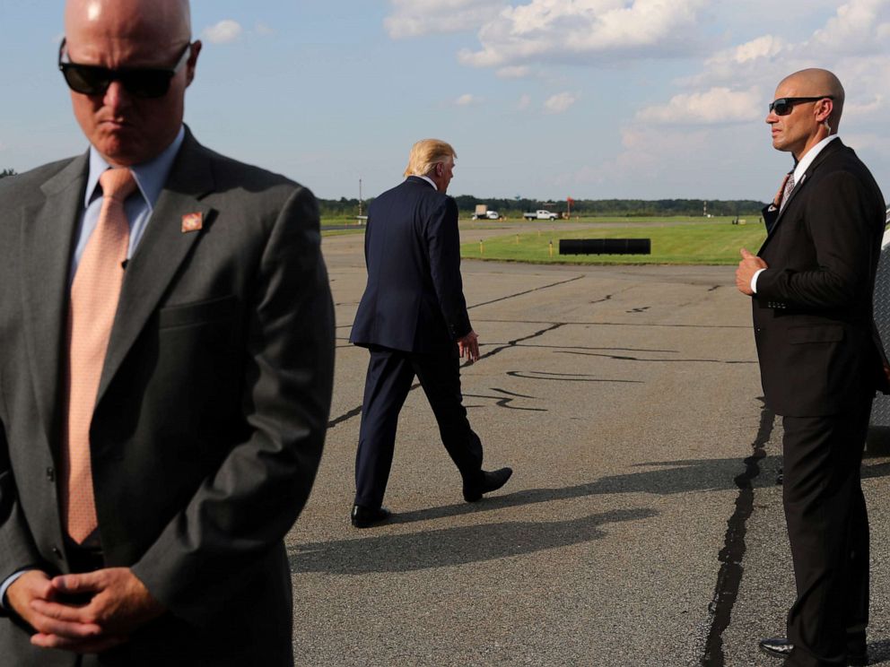 PHOTO: U.S. Secret Service agents guard President Donald Trump as he boards Air Force One to return to Washington from Morristown Municipal Airport in Morristown, New Jersey, Aug. 18, 2019.