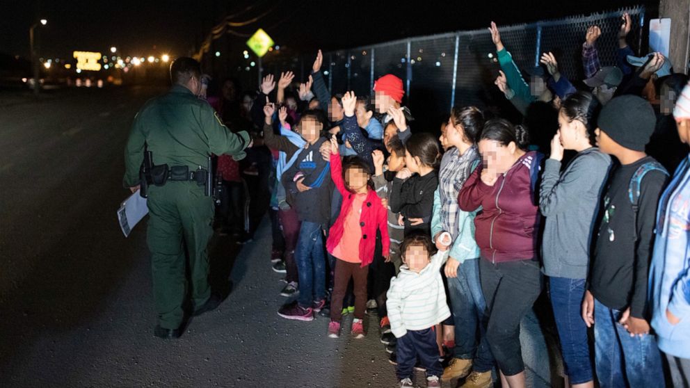 PHOTO: Migrants are seen lined up in El Paso, Texas, on March 23, 2019, after crossing the international border between the United States and Mexico and surrendering to a border patrol agent.