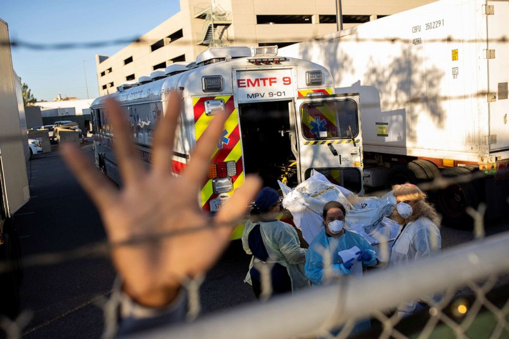 PHOTO: An El Paso County Sheriff's Officer tries to block photographs from being taken as bodies are moved to refrigerated trailers during a surge of coronavirus disease deaths, outside the El Paso Medical Examiners Office in Texas, Nov. 16, 2020.
