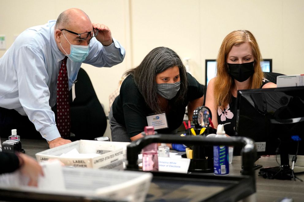 PHOTO: Miami-Dade County Supervisor of Elections Christina White, right, examines signatures on vote-by-mail ballots at the Miami-Dade County Board of Elections in Doral, Fla., Oct. 26, 2020.