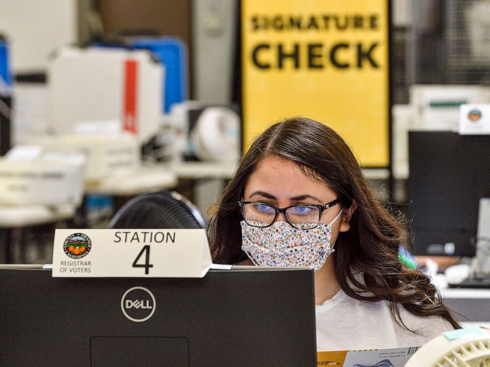 PHOTO: Workers check signatures on ballots at the Orange County Registrar of Voters in Santa Ana, Calif., Oct. 16, 2020.