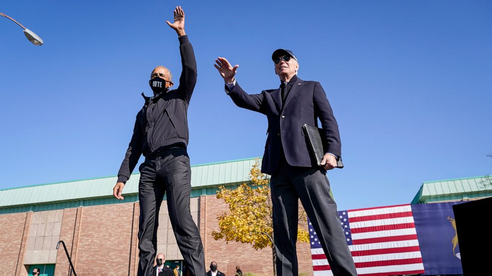 PHOTO: Former U.S. President Barack Obama and Democratic presidential nominee Joe Biden wave to the crowd at the end of a drive-in campaign rally at Northwestern High School in Flint, Mich., Oct. 31, 2020.