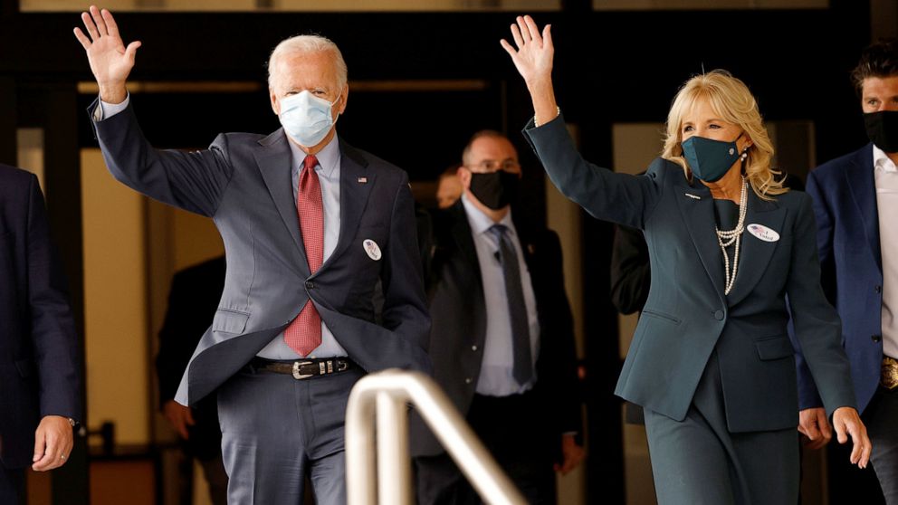 PHOTO: Democratic presidential nominee and former Vice President Joe Biden and his wife Jill wave as they depart after casting their votes in Wilmington, Del., Oct. 28, 2020.