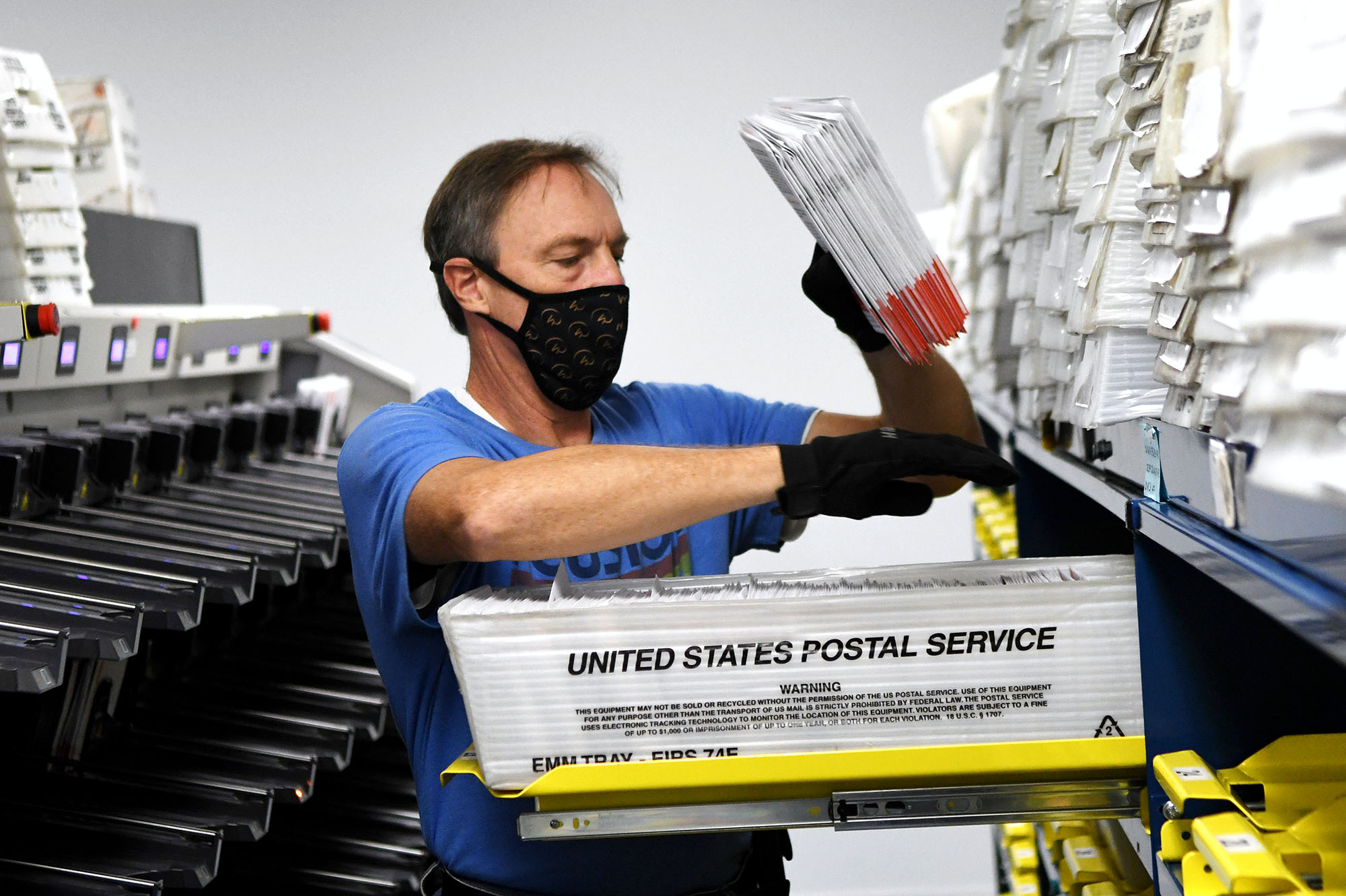 PHOTO: Michael Duve places mail-in ballots into trays in the sorting room at the Orange County Supervisor of Elections office in Orlando, Fla., Oct. 26, 2020.