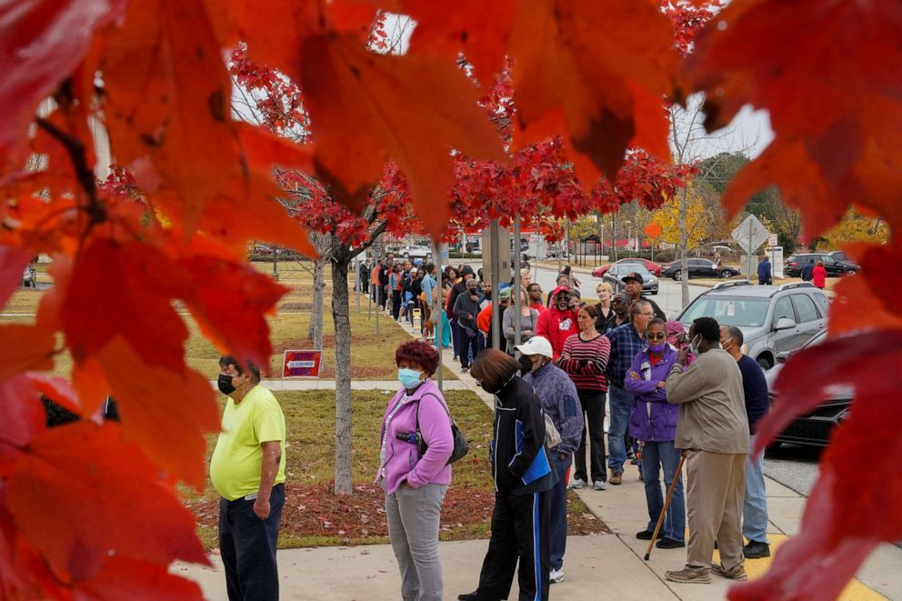 PHOTO: A line of early voters stretches outside the building at the start of early voting in the runoff U.S. Senate election between Warnock and his challenger Walker, at the City Services Center in Columbus, Muscogee County, Georgia, on Nov. 26, 2022.  
