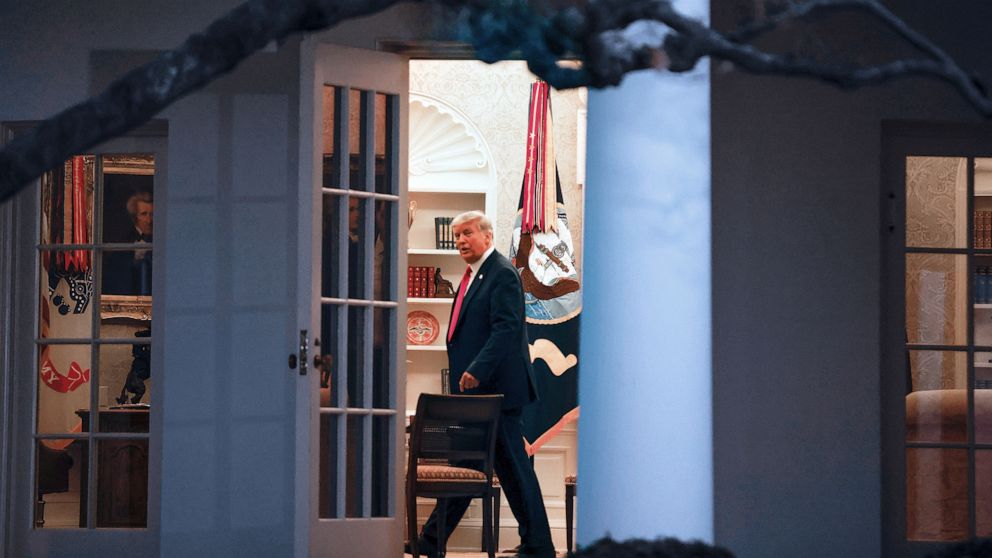 PHOTO: President Donald Trump stands by his desk in the Oval Office after returning at the conclusion of an event about the "Operation Warp Speed" program in the White House, Nov. 13, 2020.