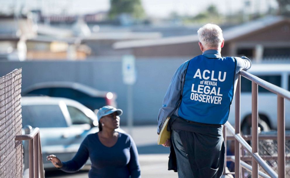 PHOTO:  A legal observer with the ACLU of Nevada stands at the entrance to the polling location as voters arrive to cast their ballots in North Las Vegas on Election Day, Nov. 8, 2016. 