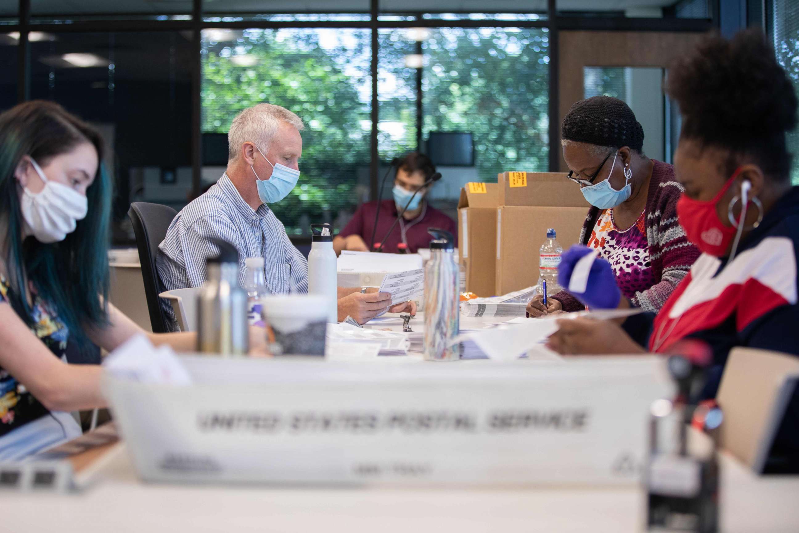 PHOTO: Absentee ballot election workers stuff ballot applications at the Mecklenburg County Board of Elections office in Charlotte, North Carolina, Sept. 4, 2020.