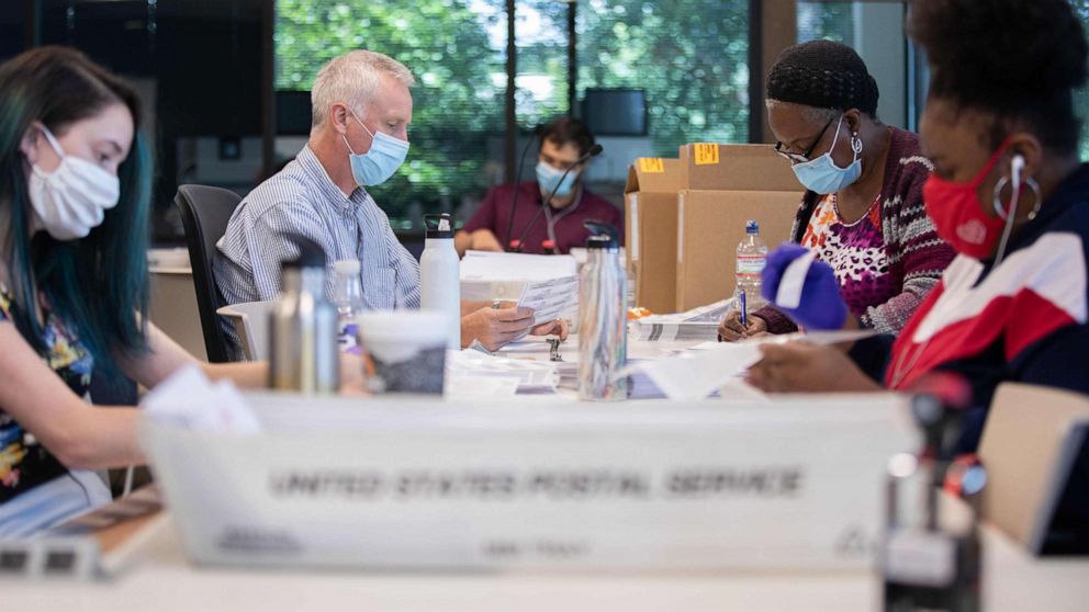 PHOTO: Absentee ballot election workers stuff ballot applications at the Mecklenburg County Board of Elections office in Charlotte, North Carolina, Sept. 4, 2020.