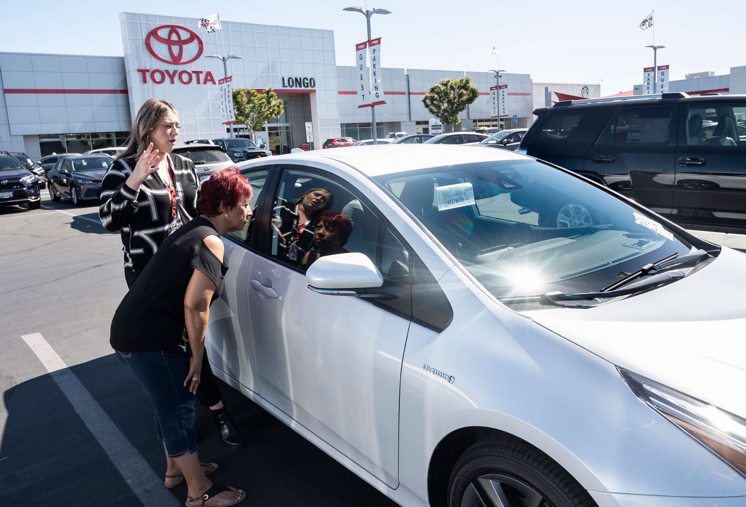 PHOTO: In this March 23, 2022, file photo, a customer is shown a 2022 Toyota Prius at Longo Toyota in El Monte, Calif.