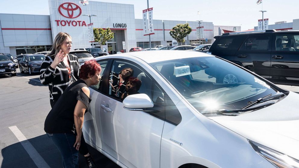 PHOTO: In this March 23, 2022, file photo, a customer is shown a 2022 Toyota Prius at Longo Toyota in El Monte, Calif.