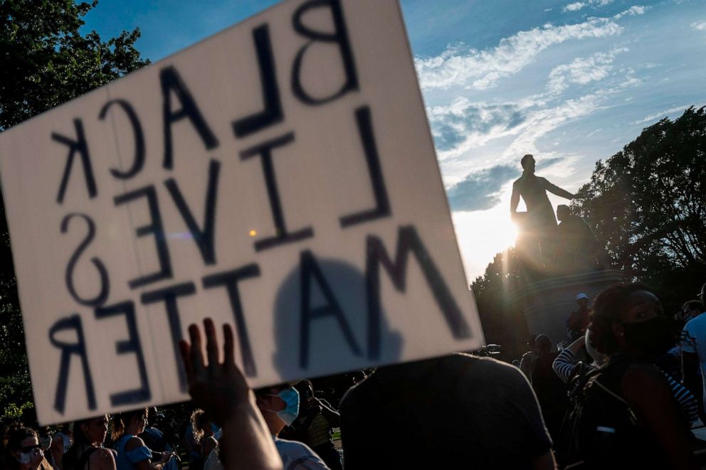 PHOTO: Protesters hold signs during a small rally in support for the removal of the Emancipation Statue at Lincoln Park in Washington, D.C., June 23, 2020.