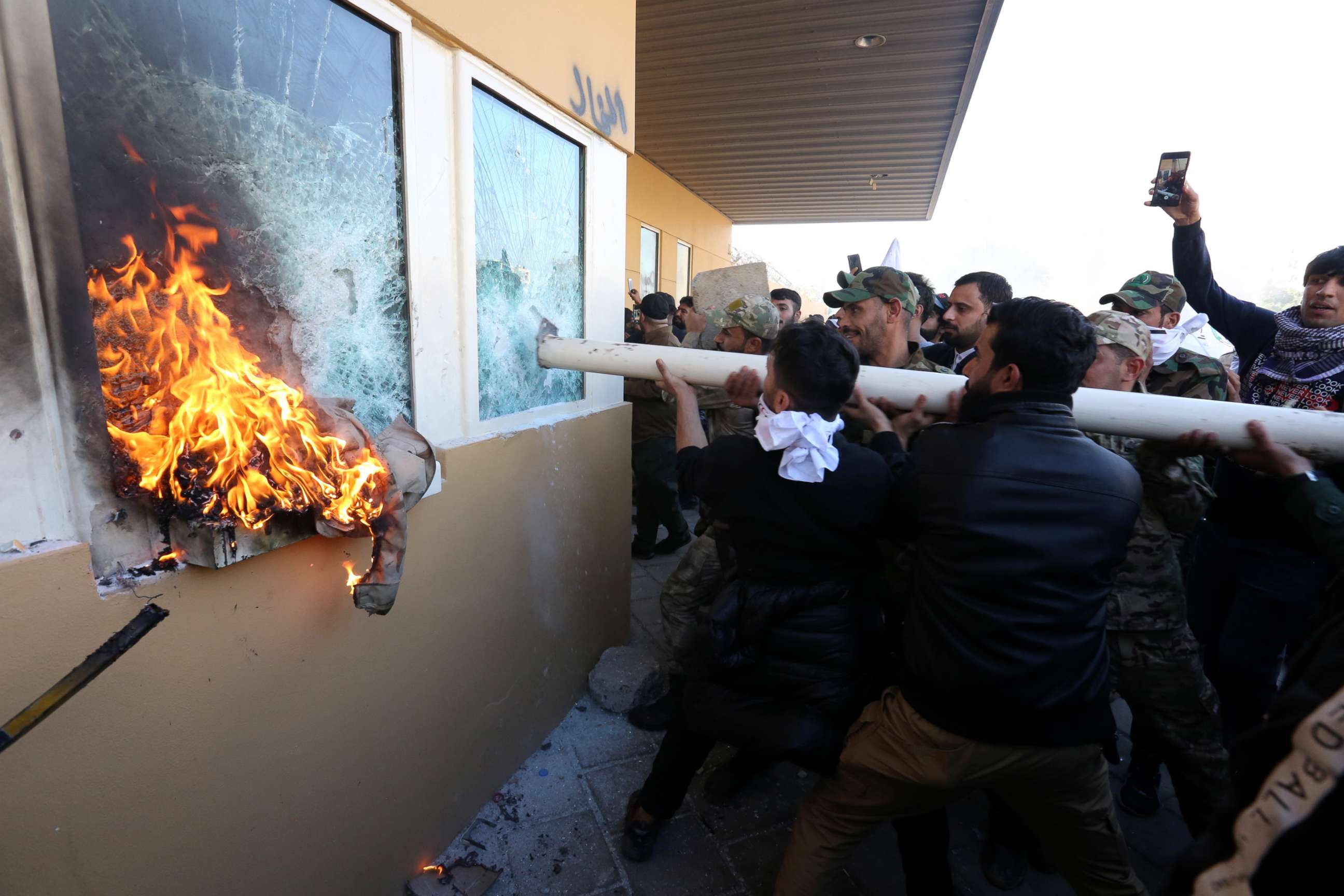 PHOTO: Members of Iraqi Shiite 'Popular Mobilization Forces' armed group and their supporters attack the entrance of the US Embassy in Baghdad, Iraq, Dec. 31, 2019.