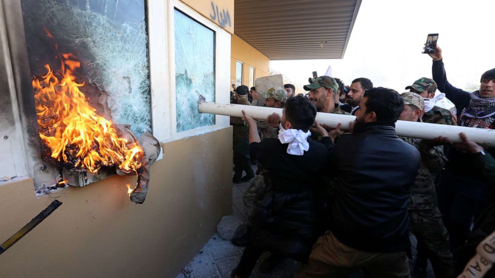 PHOTO: Members of Iraqi Shiite 'Popular Mobilization Forces' armed group and their supporters attack the entrance of the US Embassy in Baghdad, Iraq, Dec. 31, 2019.