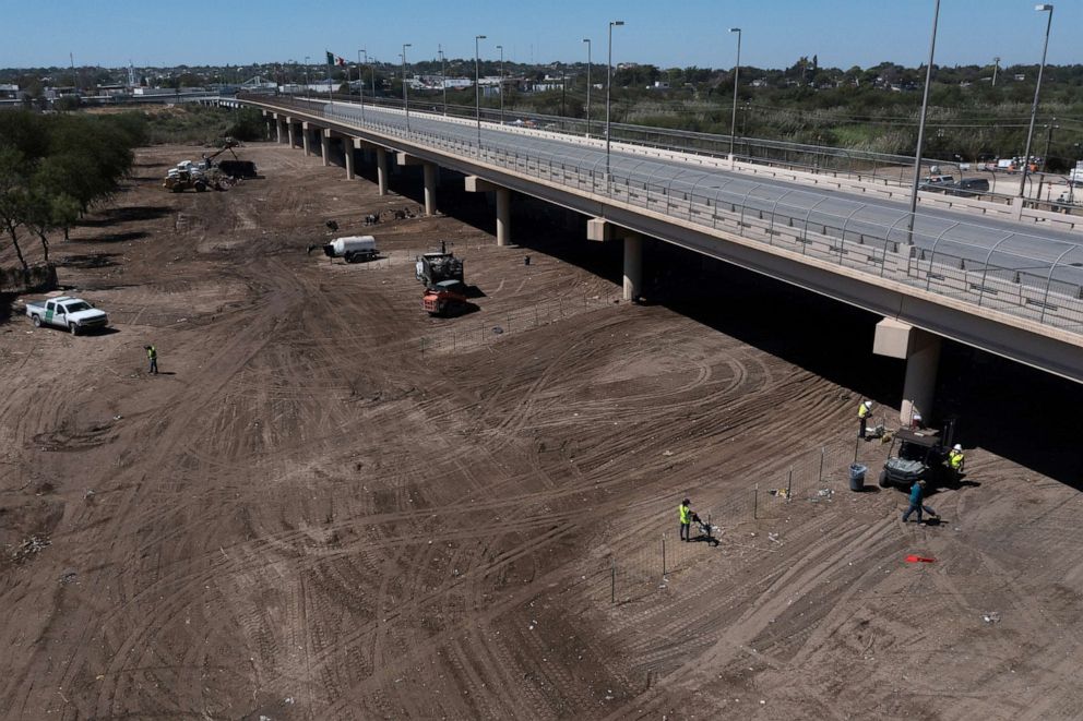 PHOTO: Workers clear debris from the site of a makeshift border migrant camp along the International Bridge in Del Rio, Texas, Sept. 24, 2021.