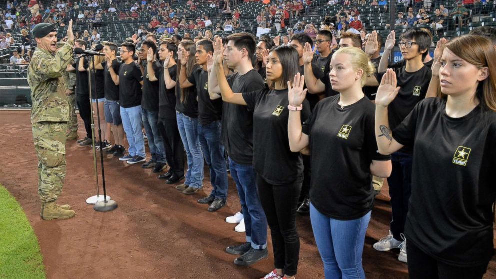 The Commander of the Phoenix Recruiting Battalion administers the oath of enlistment to a group of future soldiers before a Major League Baseball game in Phoenix, Aug. 26, 2018.