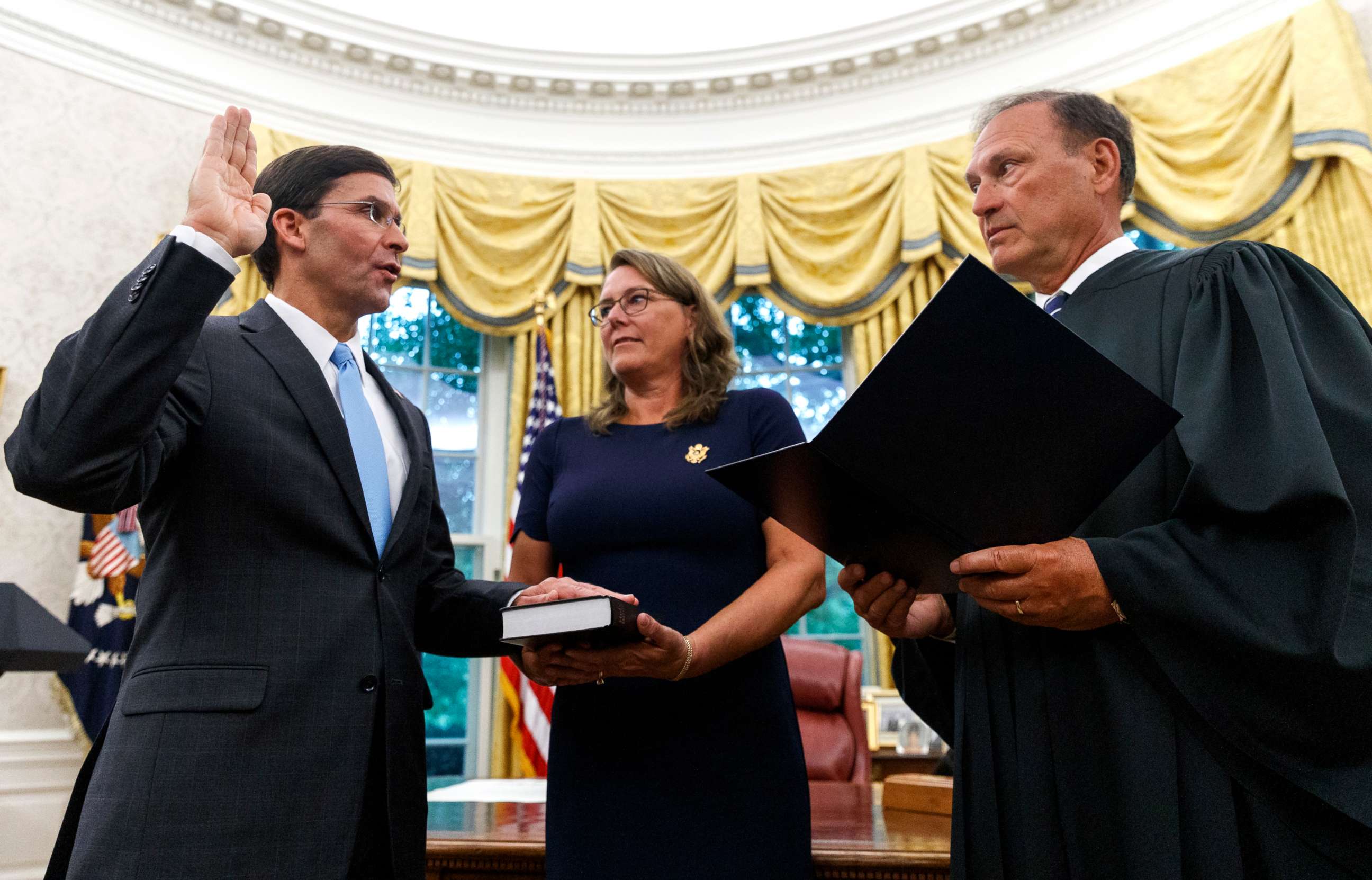 PHOTO: Mark Esper, left, is sworn in as the Secretary of Defense by Supreme Court Justice Samuel Alito, right, as is wife Leah Esper holds the Bible, during a ceremony in the Oval Office at the White House in Washington, July 23, 2019.