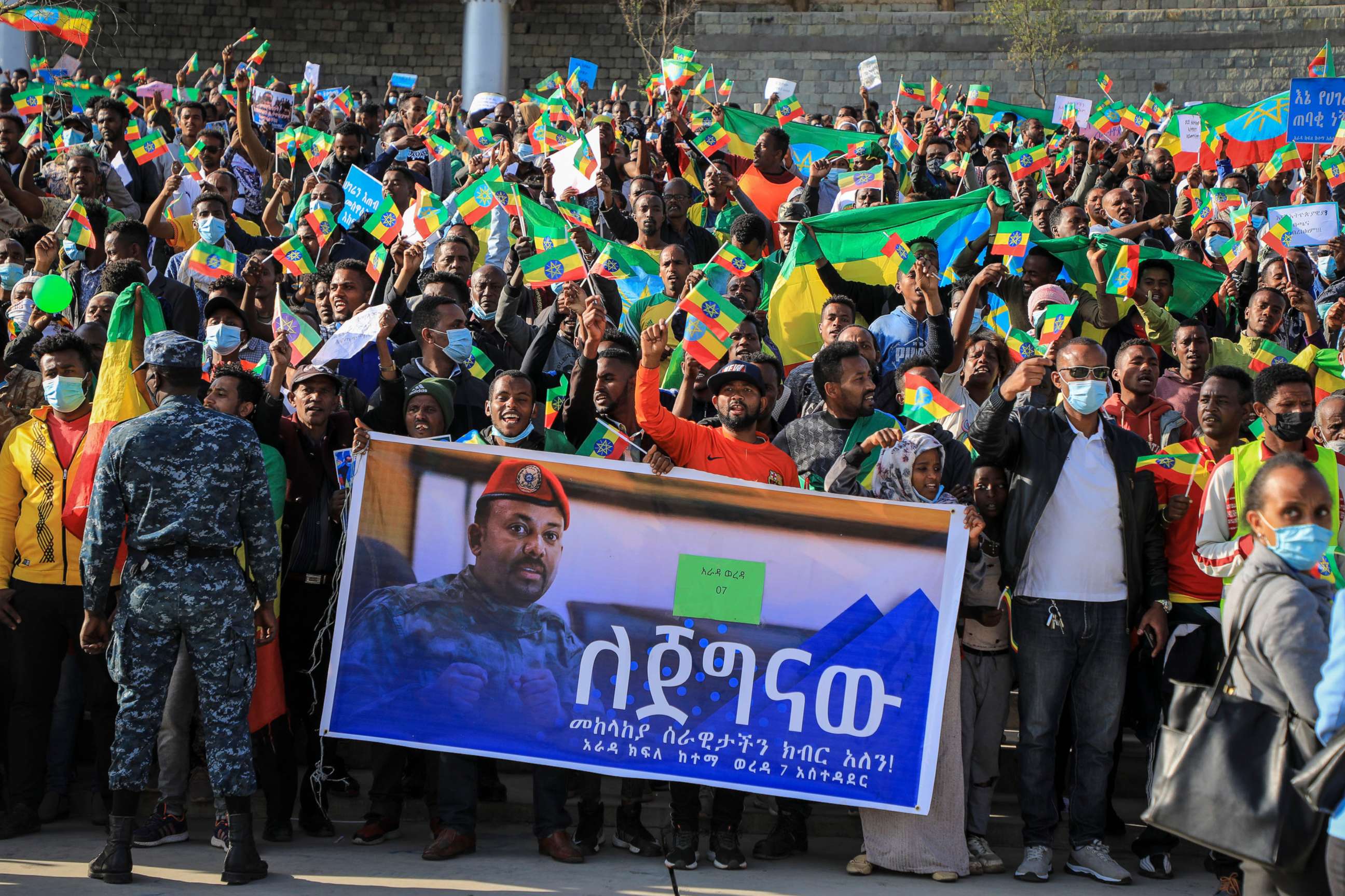 PHOTO: People gather behind a placard showing Prime Minister Abiy Ahmed at a rally organized by local authorities to show support for the Ethiopian National Defense Force, at Meskel square in downtown Addis Ababa, Ethiopia, Nov. 7, 2021.