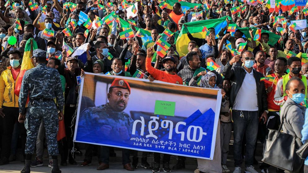 PHOTO: People gather behind a placard showing Prime Minister Abiy Ahmed at a rally organized by local authorities to show support for the Ethiopian National Defense Force, at Meskel square in downtown Addis Ababa, Ethiopia, Nov. 7, 2021.
