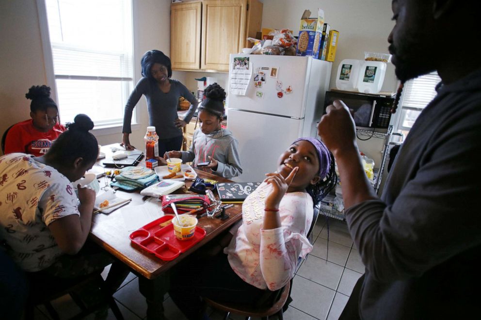 PHOTO: Robinson Paul, right, jokes with his daughter, Kennedy, 11, while the family does school work in their kitchen in the Field's Corner neighborhood of Boston, MA on March 19, 2020.