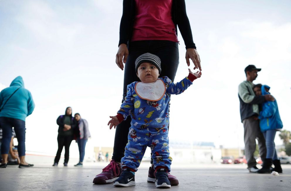 PHOTO: In this June 13, 2018 photo, nine month-old Jesus Alberto Lopez, center, stands with his mother, Perla Murillo, as they wait with other families to request political asylum in the United States, across the border in Tijuana, Mexico.