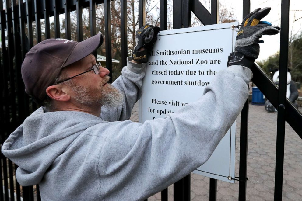 PHOTO: A Smithsonian National Zoo employee removes a sign telling visitors that the zoo is closed due to a government shutdown from the front gate, Jan. 28, 2019, in Washington, D.C.