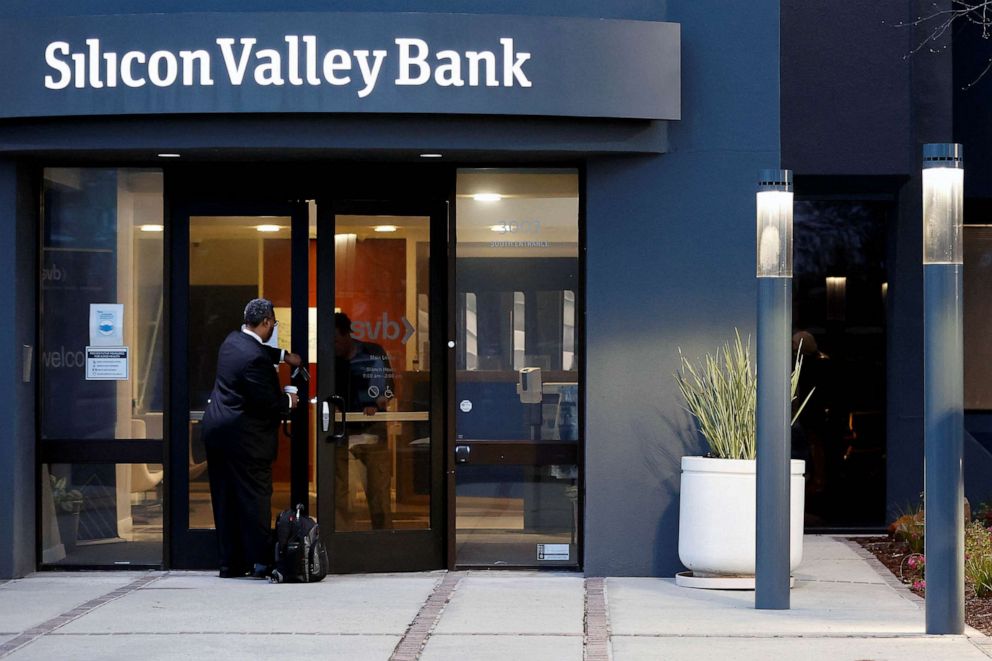 PHOTO: FILE - A bank employee waits to be let in outside of the Silicon Valley Bank headquarters in Santa Clara, Calif., March 13, 2023.