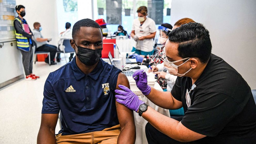 PHOTO: Pharmacy student Jason Rodriguez administers a COVID-19 vaccine to Larry Grier at the Christine E. Lynn Rehabilitation Center in Miami, April 15, 2021.