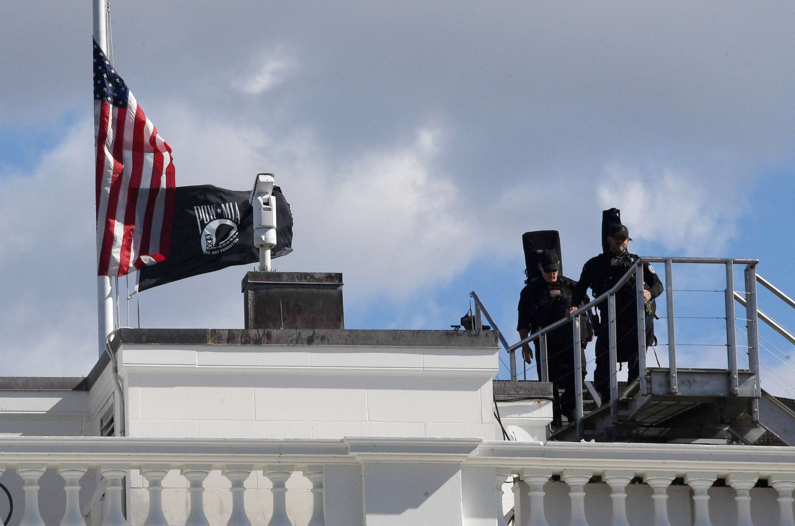PHOTO: Secret service snipers walk past the national flag at half mast atop the White House following the death of Former Secretary of State Colin Powell on Oct. 18, 2021.