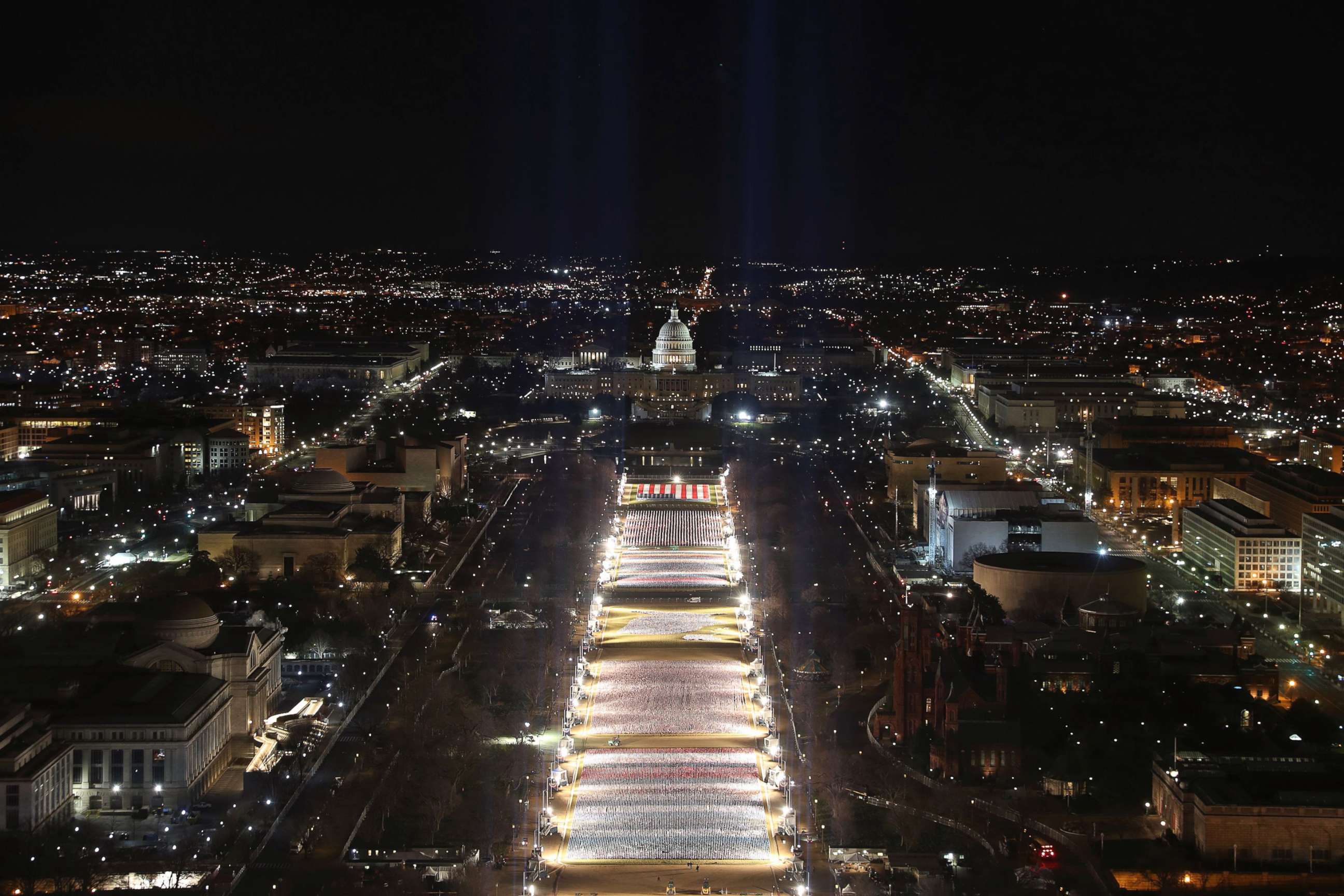 PHOTO: Blue lights are beamed into the sky over the "Field of Flags" on the National Mall as the Capitol Building is prepared for the inauguration ceremonies for President-elect Joe Biden and Vice President-elect Kamala Harris, Jan. 18, 2021.