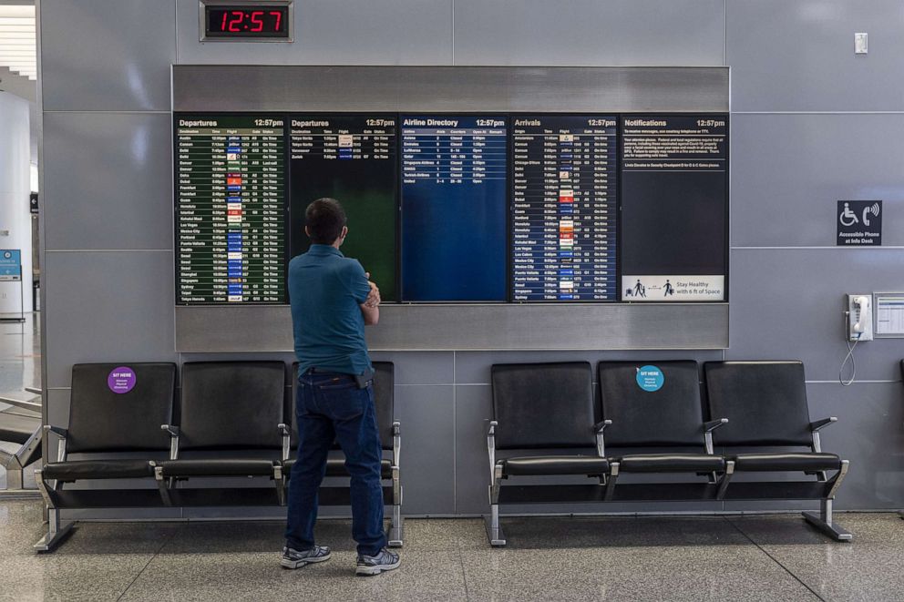 PHOTO: A traveler looks at a flight departure board inside the international terminal at San Francisco International Airport in San Francisco, Calif., May 11, 2021.