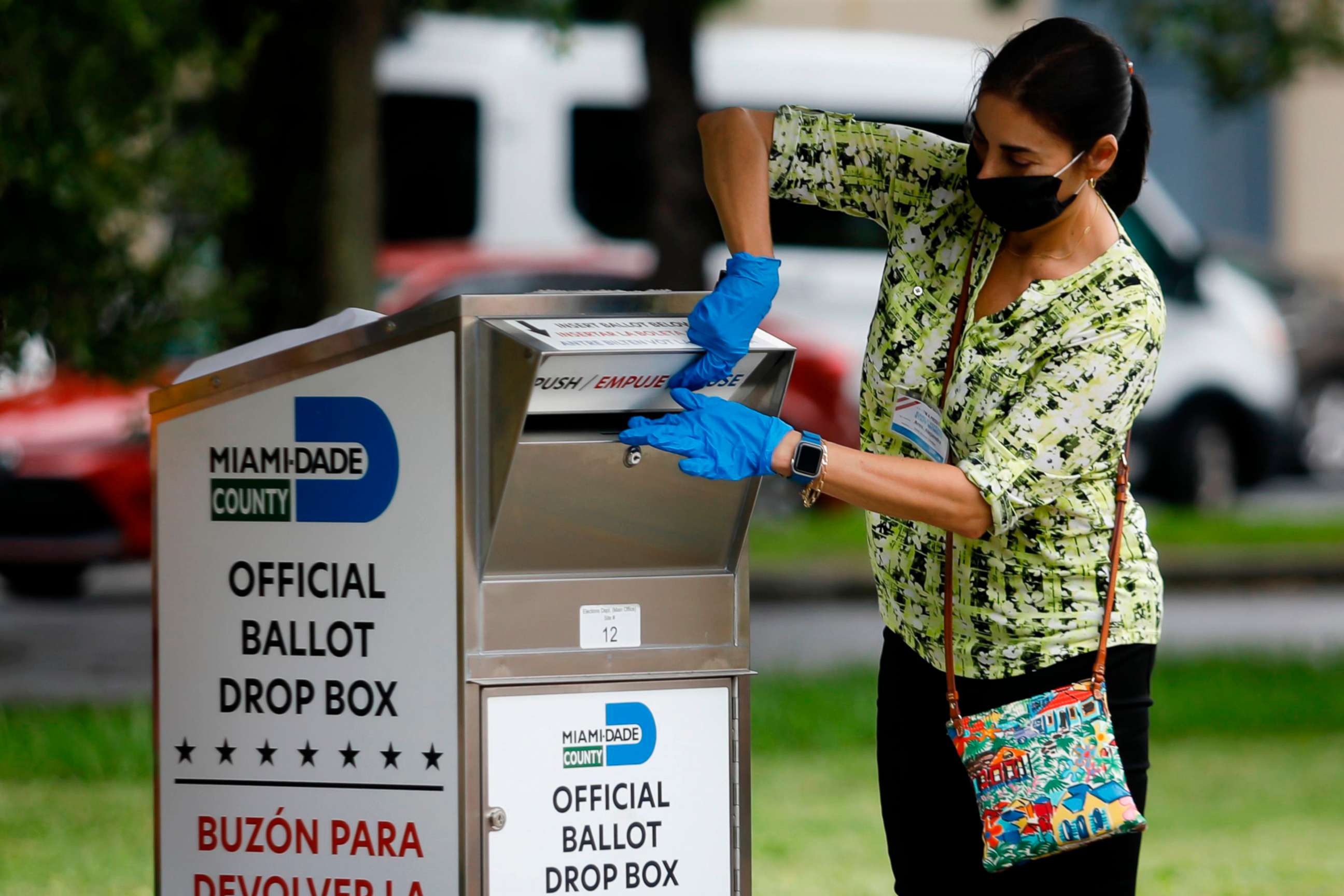 PHOTO: In this Oct. 19, 2020, file photo, a poll worker drops off a vote-by-mail ballot at a ballot drop box at Miami-Dade County Election Department in Miami.